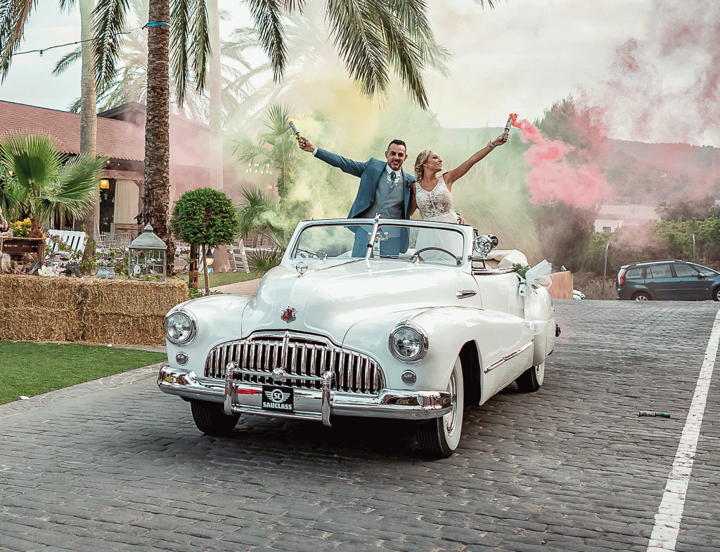 Pareja saliendo del banquete con bengalas en el Buick John Spirit